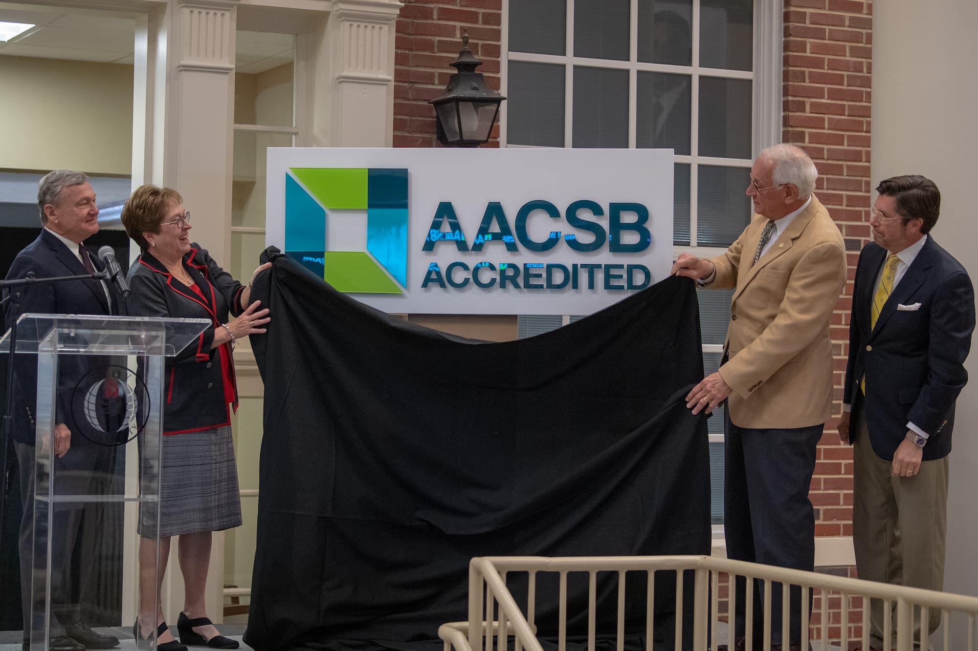 Dr. Earl Ingram, Karen Carter, Dr. Jack Hawkins, Jr. and Dr. Judson Edwards unveil a sign noting the AACSB Accreditation of the Sorrell College of Business