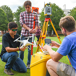 Students using surveying equipment. 