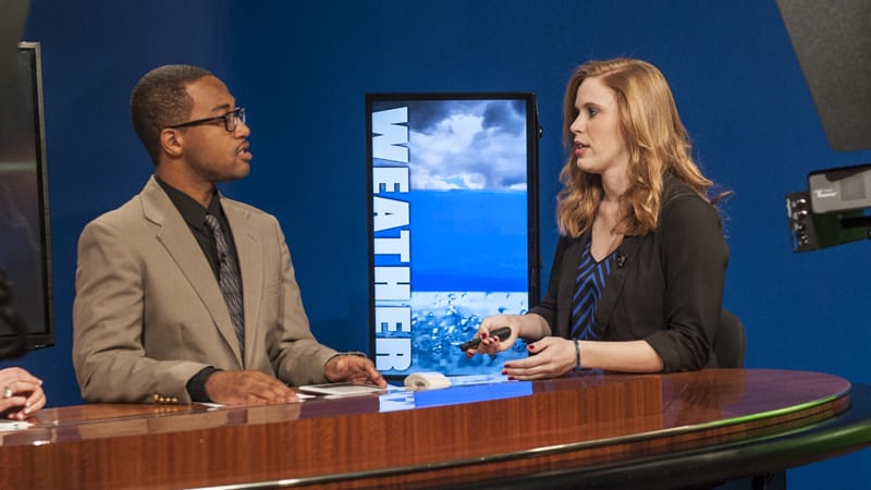 Students Jarmarlo Phillips and Haley Greathouse discuss the weather on TROY TrojanVision News
