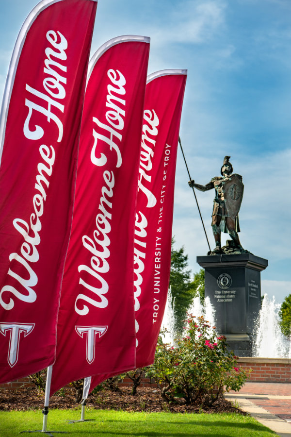 A series of red flags reading: Welcome Home - Troy University and the City of Troy