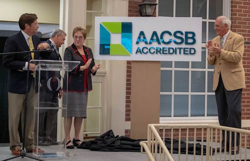 Sorrell College Dean Dr. Judson Edwards, left, is joined onstage by Chancellor Hawkins, right, Senior Vice Chancellor for Academic Affairs Dr. Earl Ingram,  and Trustee Karen Carter to announce the college’s accreditation through AACSB, earning the University elite status among business schools.