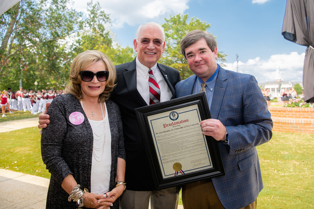 Troy Mayor Jason Reeves, a TROY alumnus, presents Dr. and Mrs. Jack Hawkins, Jr. with a resolution honoring Dr. Hawkins’ 30th year as the University’s Chancellor.