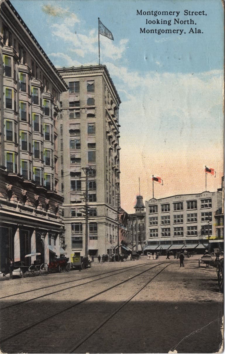 Color print of Montgomery Street in Montgomery, Alabama showing multi-story buildings and streetcar rails. Postmarked September 21, 1917.