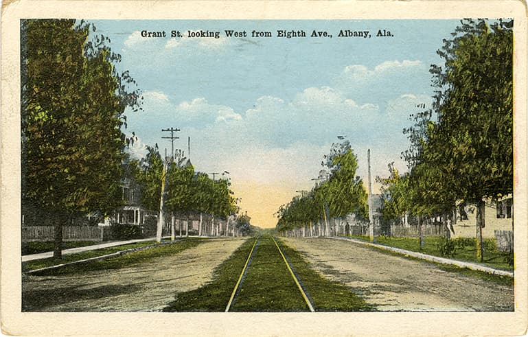 Color print of residential Grant Street in Albany, Alabama with streetcar rails running down the center. Postmarked September 7, 1946. 