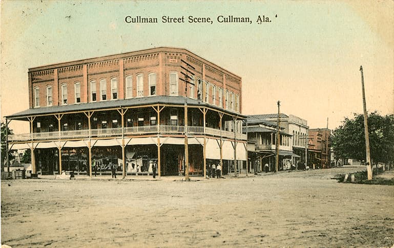 Color print of a three-story building and other commercial buildings in Cullman, Alabama. Postmarked May, 25, 1909.