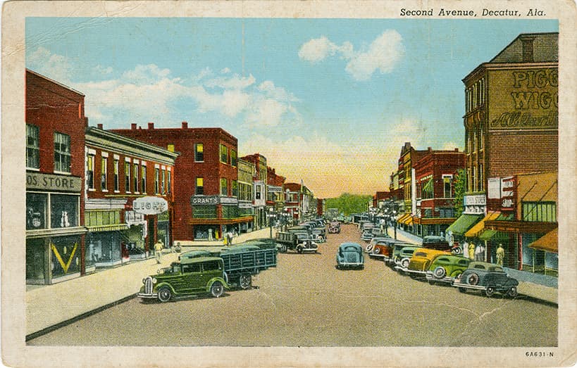 A color print of one, two, and three-story commercial buildings on Second Street in Decatur, Alabama.