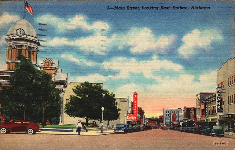 Color print of Main Street in Dothan, Alabama showing courthouse and commercial buildings. Postmarked April 26, 1948.