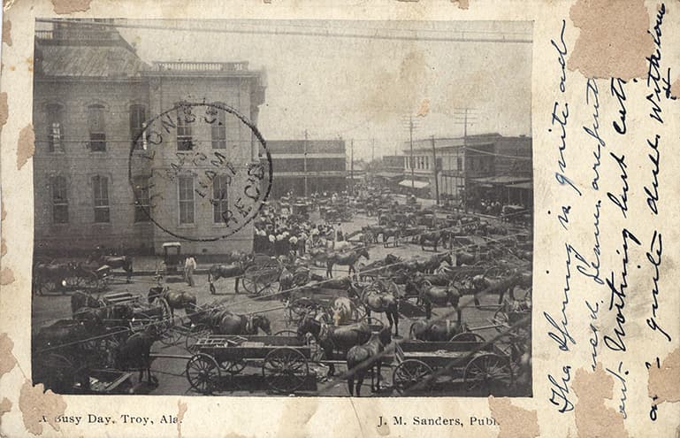 Black and white photo of downtown Troy, Alabama showing the courthouse and many horses and wagons. Postmarked March 8, 1907.