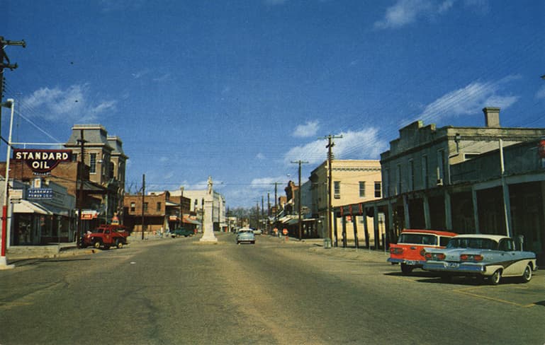 Color photograph of a monument located in the center of a street in the business section of Union Springs, Alabama.