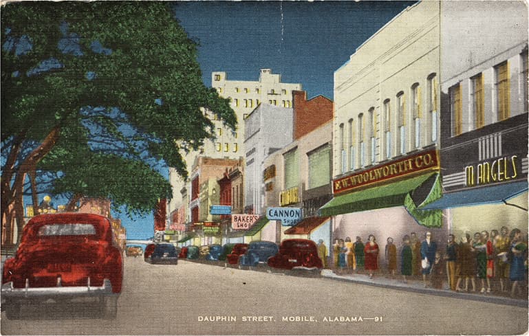 Color print of Dauphin Street in Mobile, Alabama showing multi-story commercial buildings.