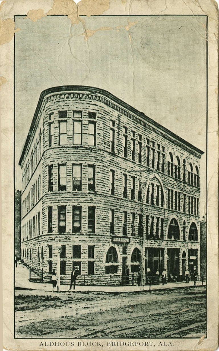 Black and white print of a multi-story building called Aldhous Block in Bridgeport, Alabama. Postmarked June 21, 1913.