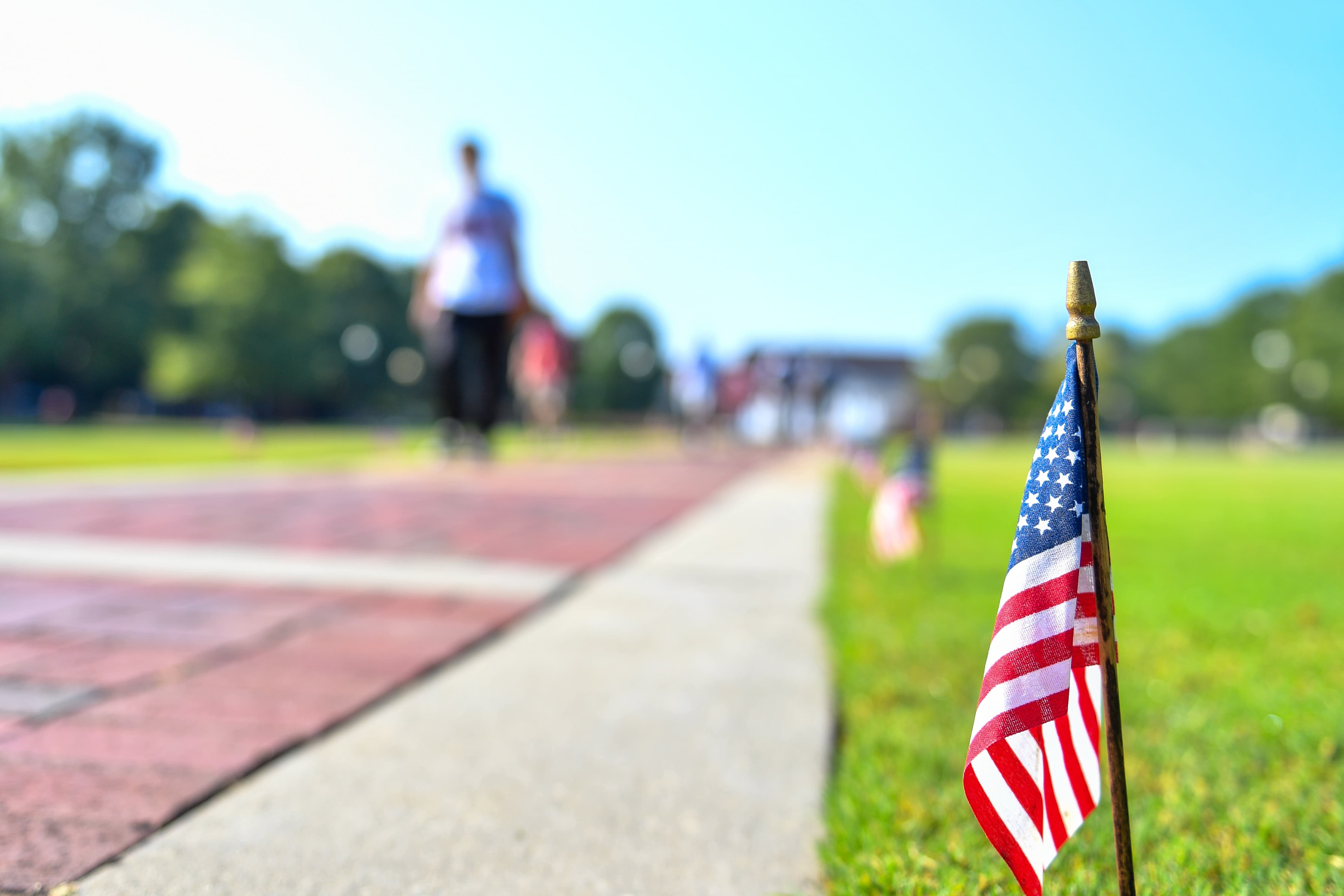 Members of the military walking on the field at a Troy University football game. 