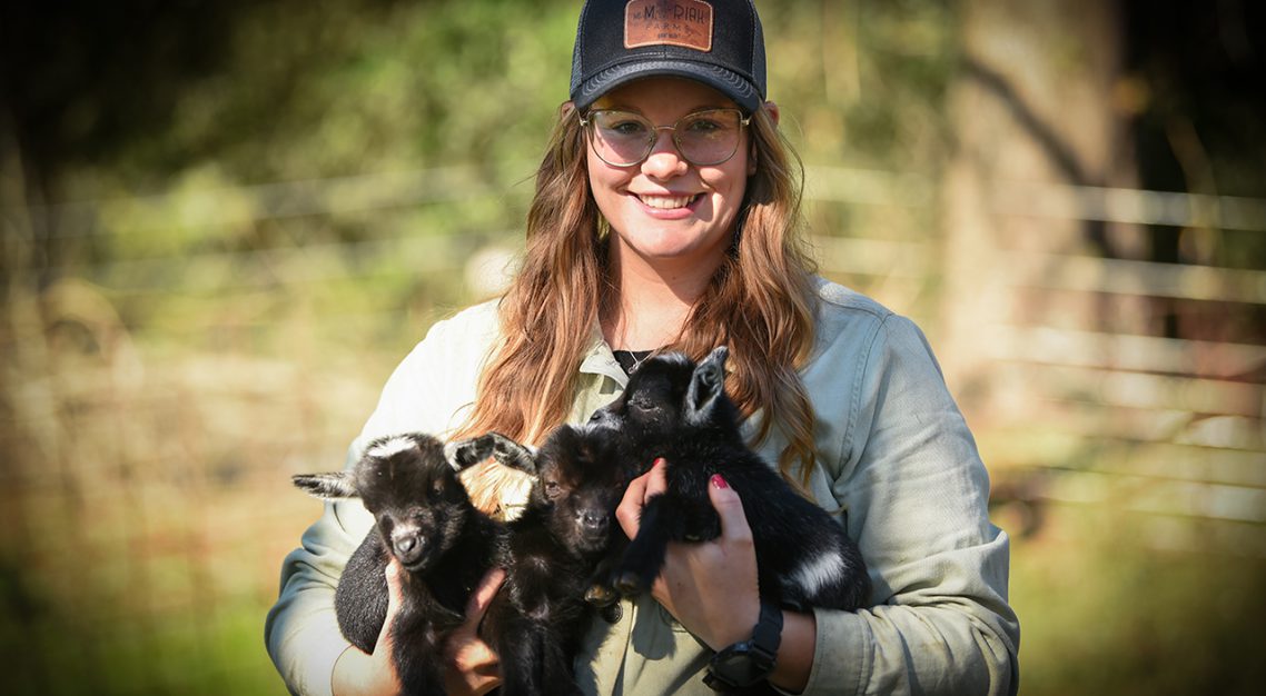 Business owner holding goats.